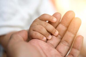 Baby hand holding mother's hands